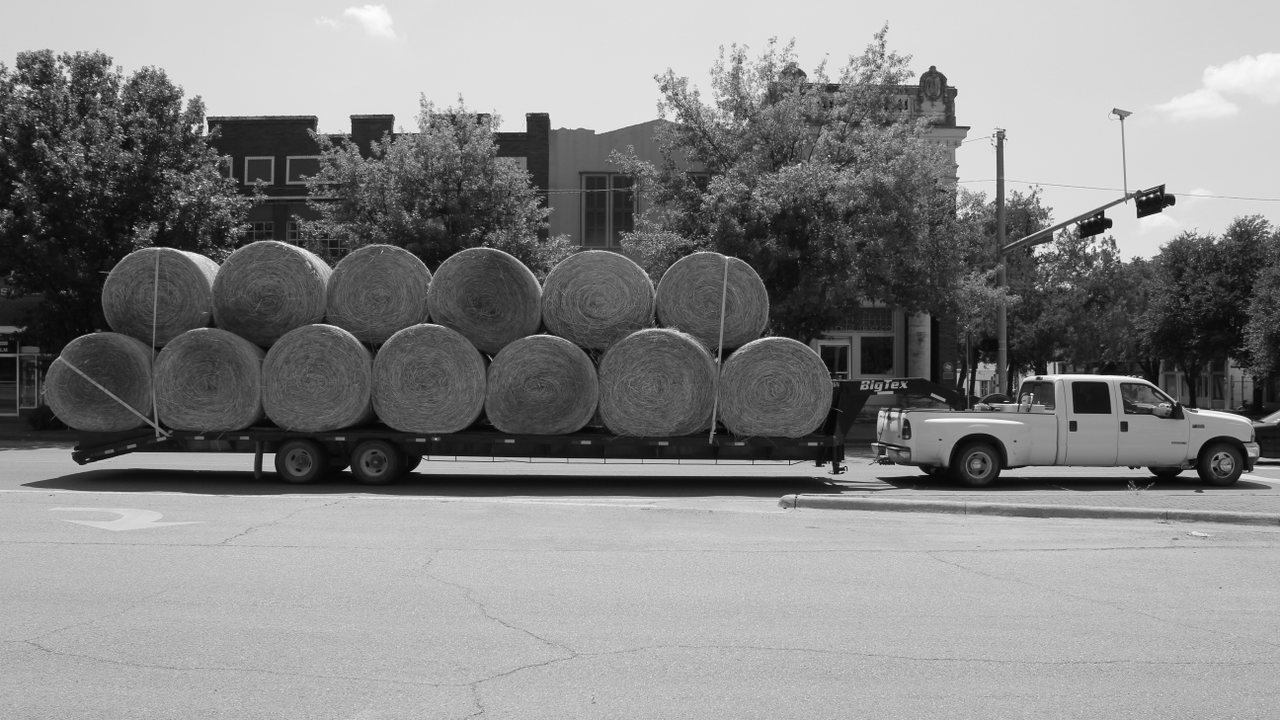 Ford F-350 diesel dually hauling hay on a road in Hillsboro, Texas