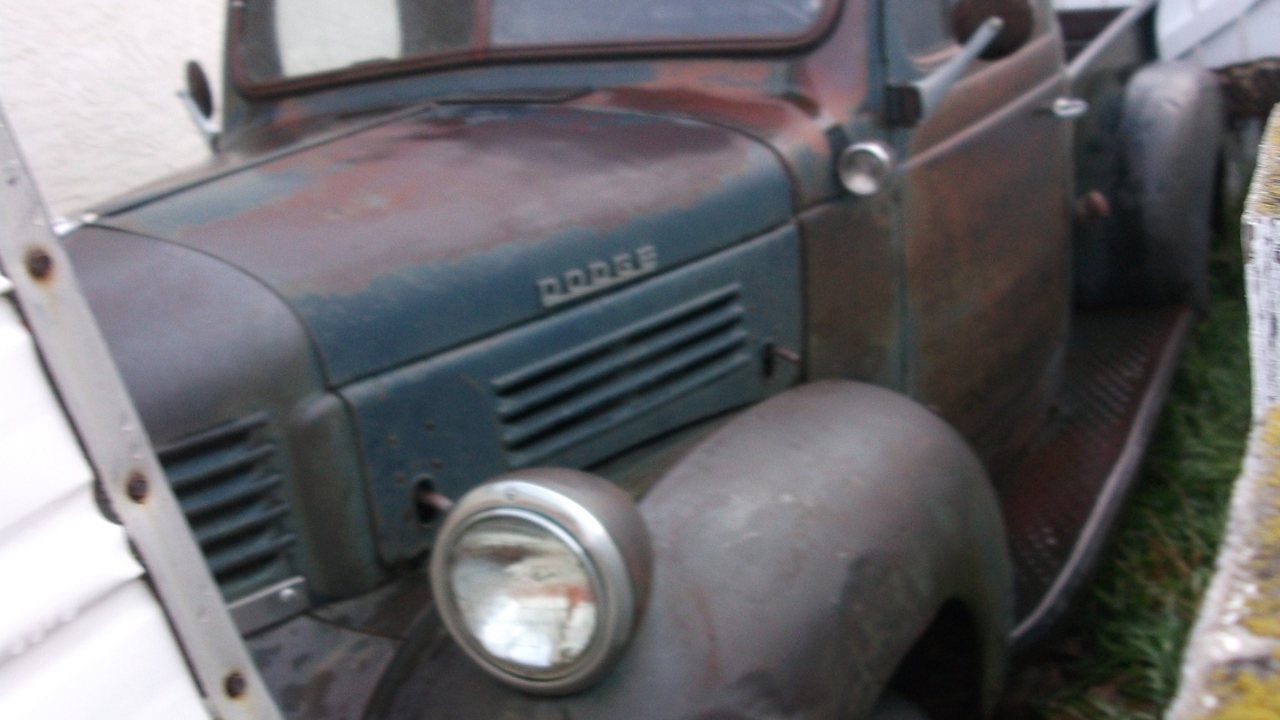 Rust-covered vintage Dodge pickup truck showing advanced exterior corrosion