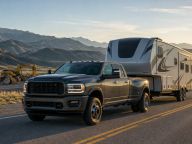 Heavy-duty diesel pickup towing a fifth-wheel trailer on an open highway