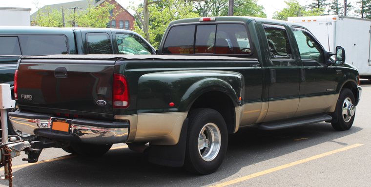 Rear three-quarter view of a 2000 Ford F-350 7.3L Power Stroke dually towing a trailer